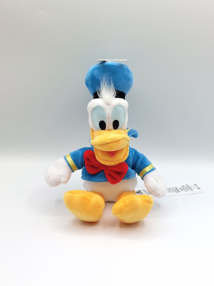 Peluche doudou Donald Duck DISNEYLAND Disneystore noeud rouge 30 cm comme neuf