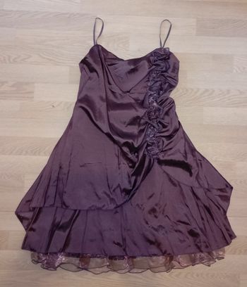 Robe de soirée ou de cérémonie satinée couleur violine avec des jolies fleurs sur le devant côté gauche et des pans asymétriques
T. XXXL