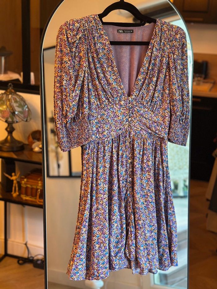 Robe courte Zara à motif fleuri dans les tons violets, jaunes et bleus.