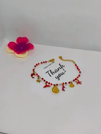 Bracelet doré et rouge avec perles de cristal et breloques de la mer