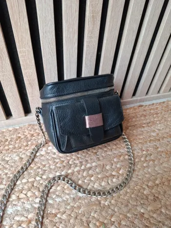 Petit sac noir bandoulière chaîne argentée.