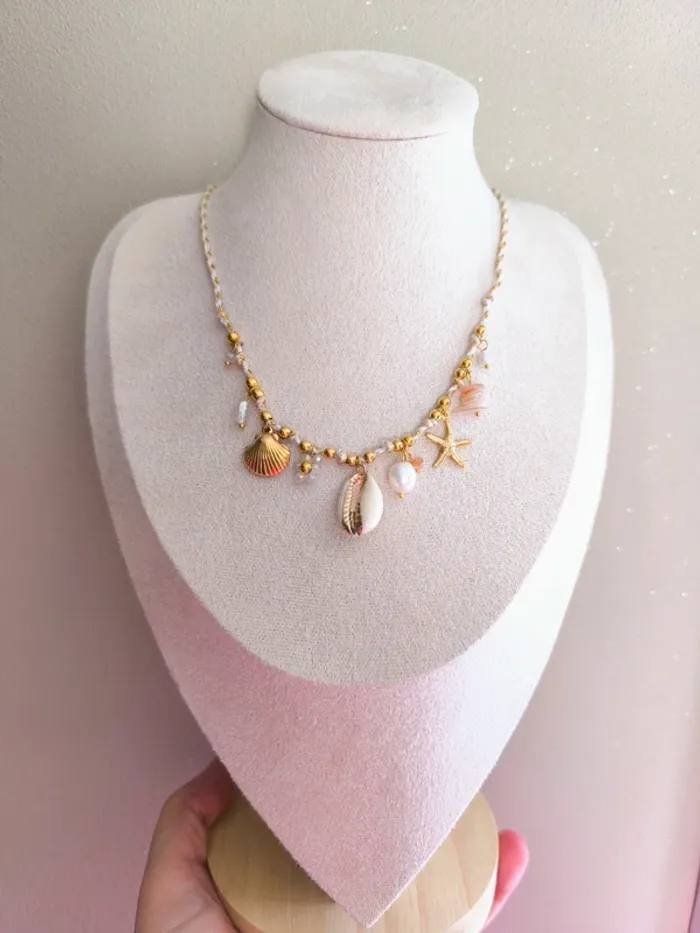 Collier doré et beige avec charms marins et fleur
