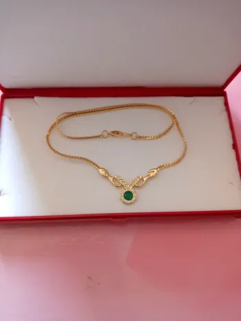 Collier doré et pierre verte