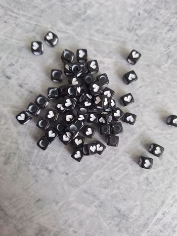 Perles noires carrées cœurs blancs