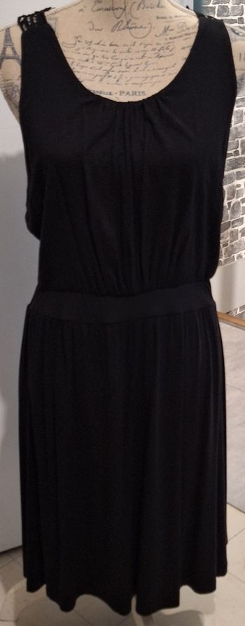 Jolie robe féminine noire sans manches avec le dos en dentelle ajourée