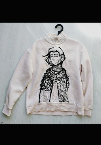 sweat Zara femme de couleur écru avec un imprimé visage et un col côtelé.