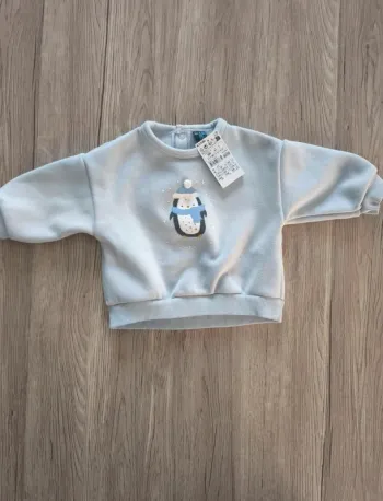 Sweat bleu ciel avec pingouin pompon en relief
