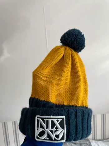 Bonnet à pompons bleu et jaune Nixon