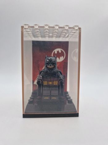 Figurine type lego Batman DC Comics dans une vitrine individuelle avec fond