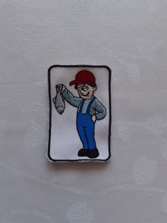 Ecusson petit enfant tiens un poisson brodé à coudre