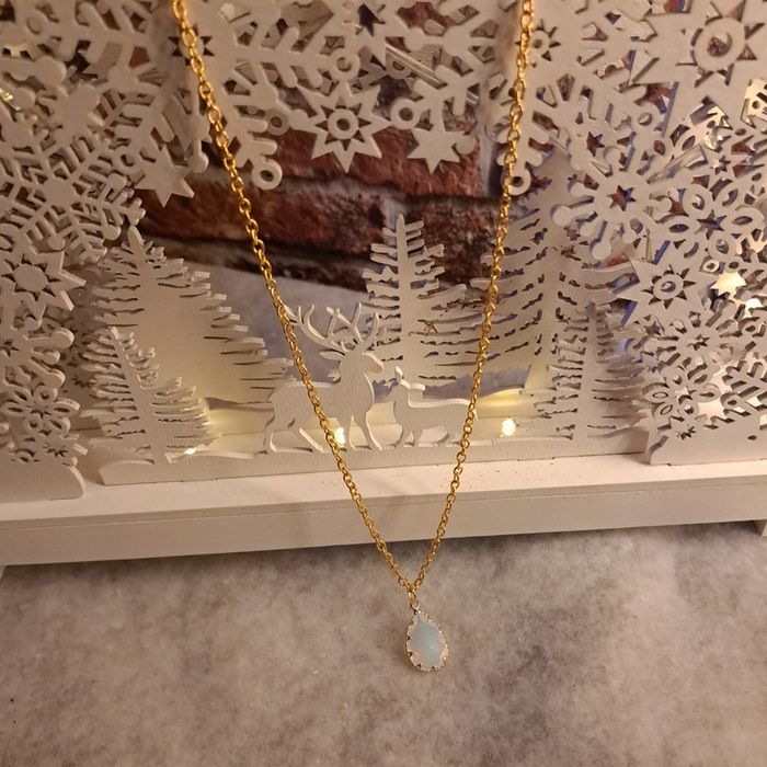 Collier doré avec pendentif blanc translucide et doré
