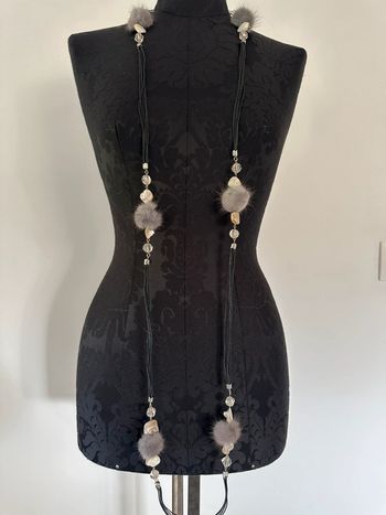 Long collier a pom-poms