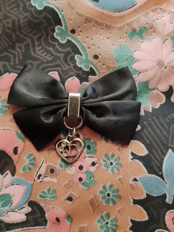 broche en métal argenté et tissu noir.