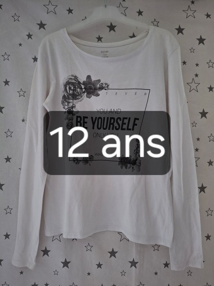 Tee-shirt blanc avec Inscription noir et fleurs 12 ans Kiabi
Très bon état ni trous ni tache
