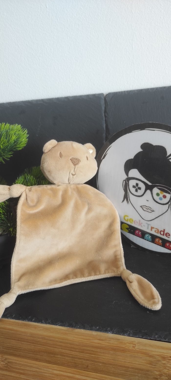 doudou édition Les quatres fleuves ours marron beige plat noeud carré grelot