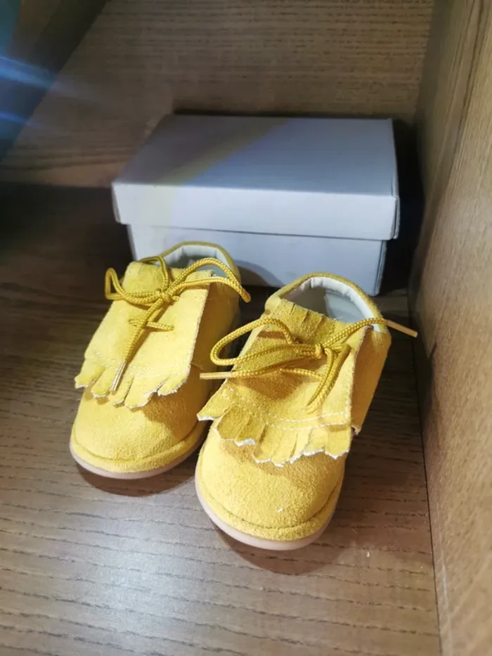 Chaussures bébé couleur moutarde.