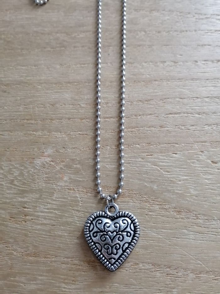 Long collier argenté pendentif cœur à motifs neuf
