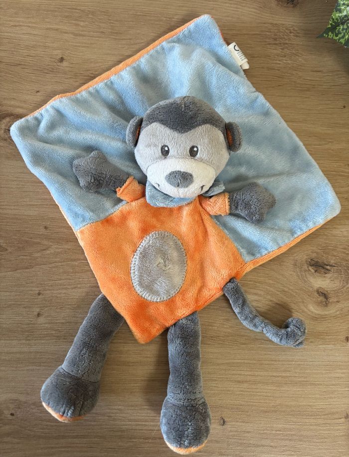 Doudou plat singe orange bleu gris nicotoy Simba