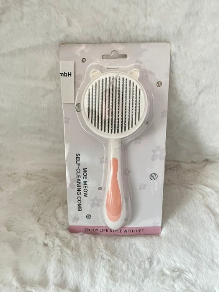 Brosse pour chat et chien autonettoyante blanche et rose