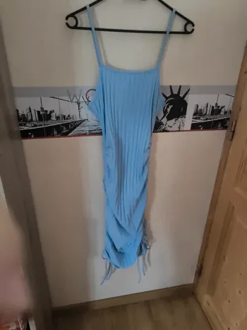Robe bleu, resserrée sur les côtés. Peut se porter court comme long