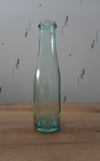 Bouteille de lait ancienne en verre soufflé avec collerette. 