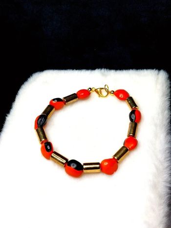 Magnifique bracelet en perles couleur doré et orange.