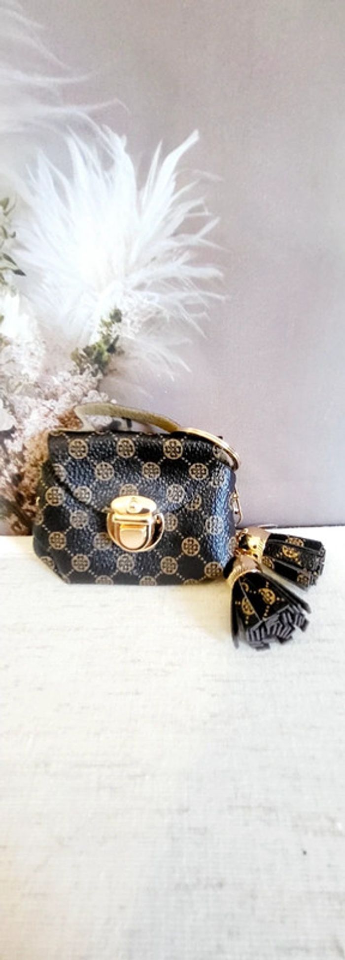 Porte-clés mini sac marron à motifs dorés avec pompons