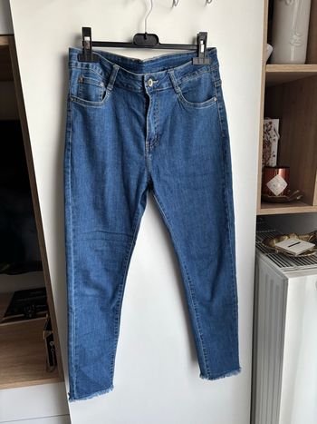 Jean bleu brut taille haute  à mini frange en bas taille L