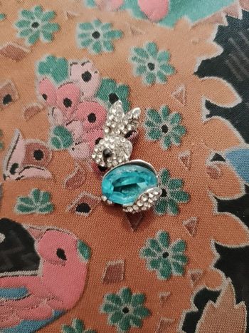 pendentif lapin en métal argenté et Strass bleues /translucides.