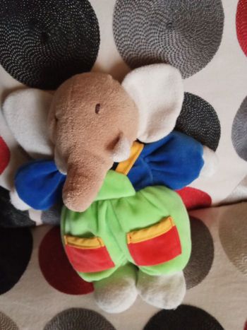 Doudou éléphant peluche style Babar de la marque Ajena tête beige marron clair bras bleu 22 cm salopette verte claire d'occasion vintage ancien en posture debout