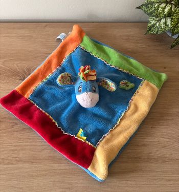 Doudou plat âne bourriquet bleu orange rouge fleur abeille Disney