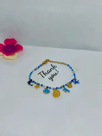 Bracelet doré et bleu avec perles de cristal et breloques de la mer