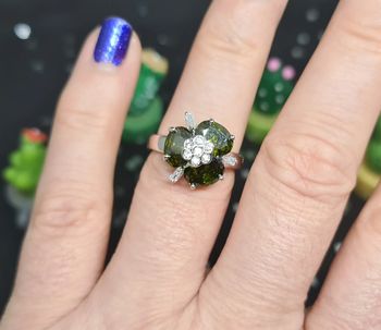 Bague fantaisie argentée avec fleur à pierres vertes et zirconiums
