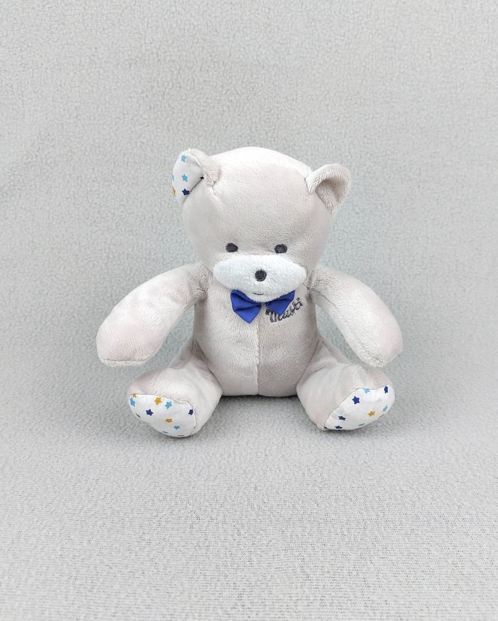 Doudou peluche ours MUSTI MUSTELA gris blanc nœud papillon bleu étoiles 18 cm