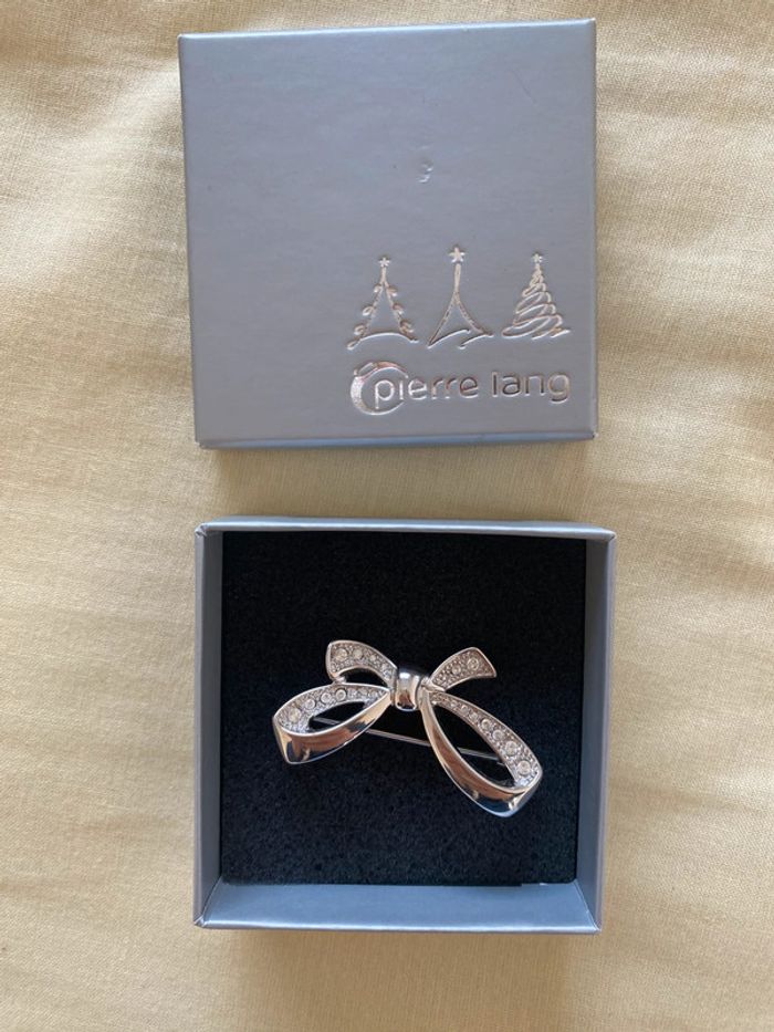 Broche noeud argenté pierre Lang