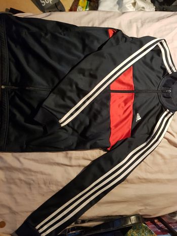 Titre
Adidas – veste noire avec bandes blanches et bande rouge