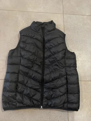 Doudoune sans manche noir, taille L, bon état mais il y a deux marques