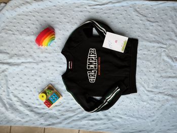 sweat noir bandes vert et blanc sur les manches inscription devant XS jennyfer