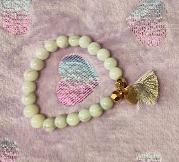 Bracelet perles marbrées avec petit pompon et breloque dorée pour femme