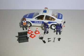 Ensemble voiture de police Playmobil avec personnages et accessoires.