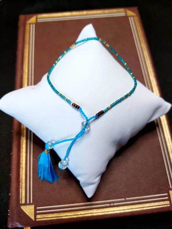 Magnifique bracelet ajustable perles et cordelette bleu avec pompon.