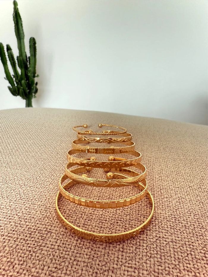 7 Bracelets ouverts dorés acier