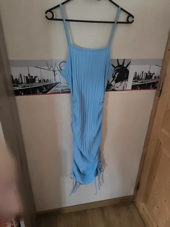 Robe bleu, resserrée sur les côtés. Peut se porter court comme long