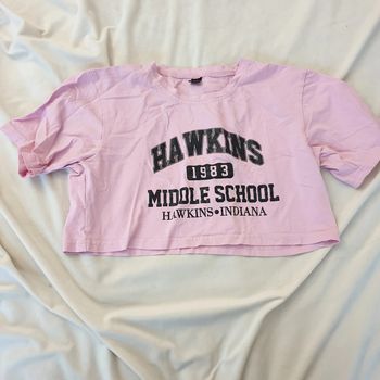 1 t-shirt rose taille S, en très bon état, à l'effigie Hawkins