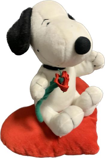 Snoopy avec une rose posé sur un coeur peluche Snoopy
