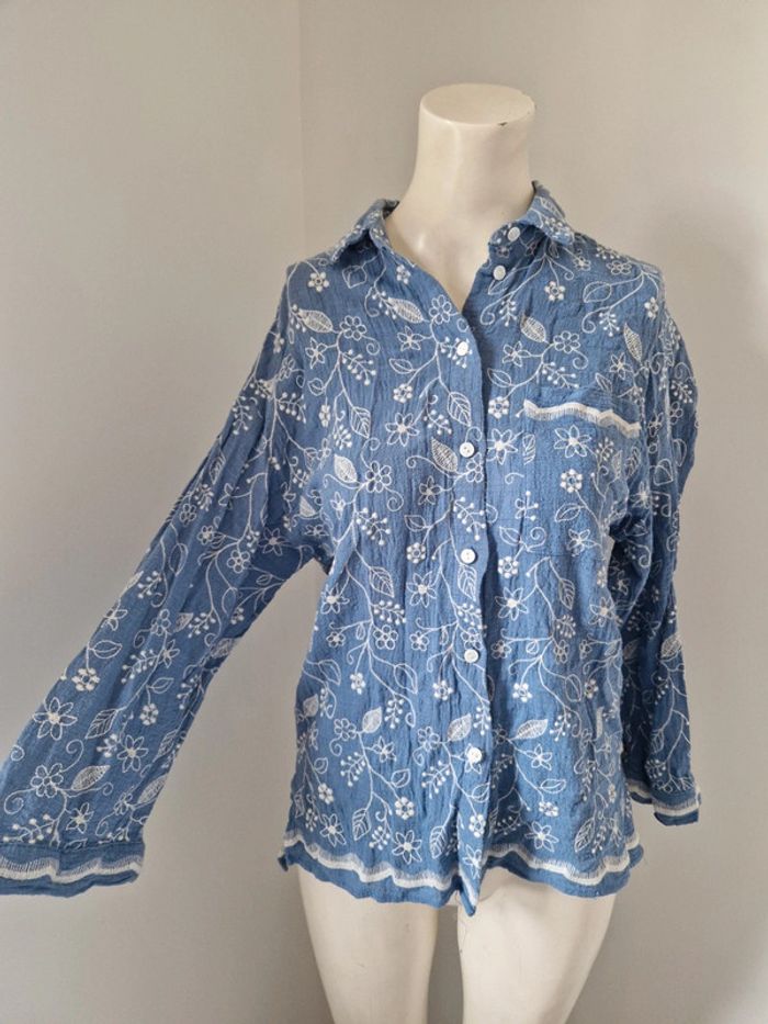 Chemise bleue à broderies fleurs feuilles beige poche devant