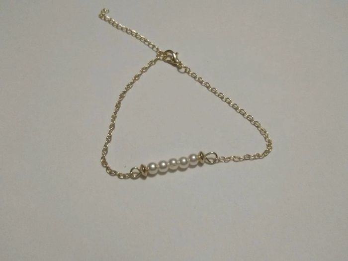 Bracelet doré avec perles blanches