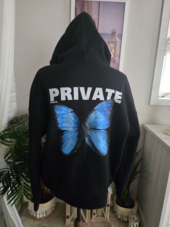 Sweat-shirt noir à capuche avec papillon bleu