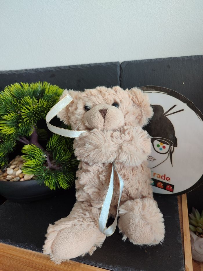 doudou peluche ours marron beige fourrure noeud bleu doré ruban Bras Croisés