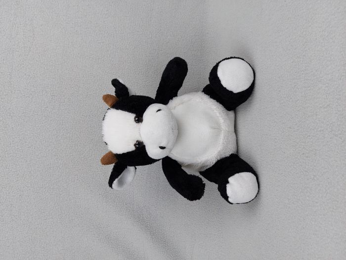 Peluche doudou vache blanc noir marron 23 cm assis yeux durs